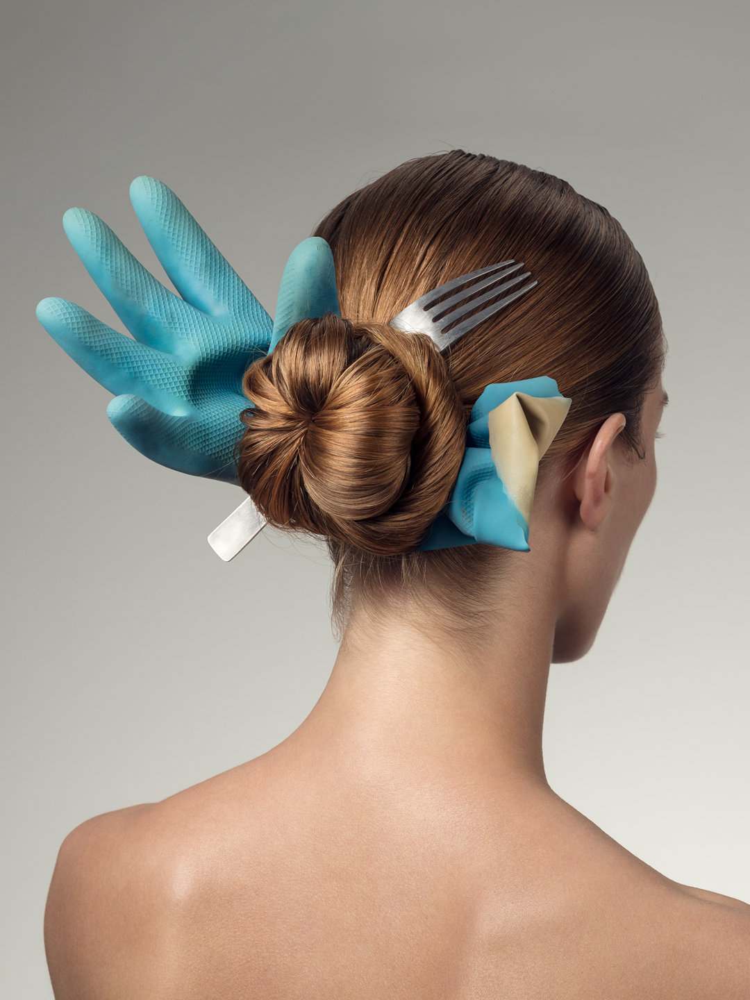 Woman's prison bun hairstyle with fork and used rubber glove